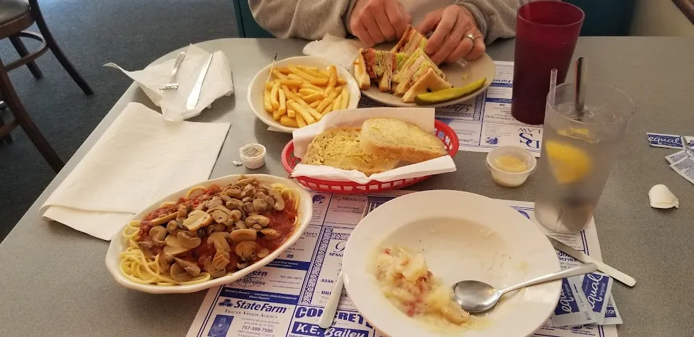 Spaghetti with Meat Sauce and Topped with Mushrooms the Other Plate Is a Club Sandwich